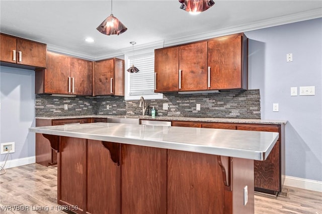 kitchen featuring pendant lighting, crown molding, and a breakfast bar area