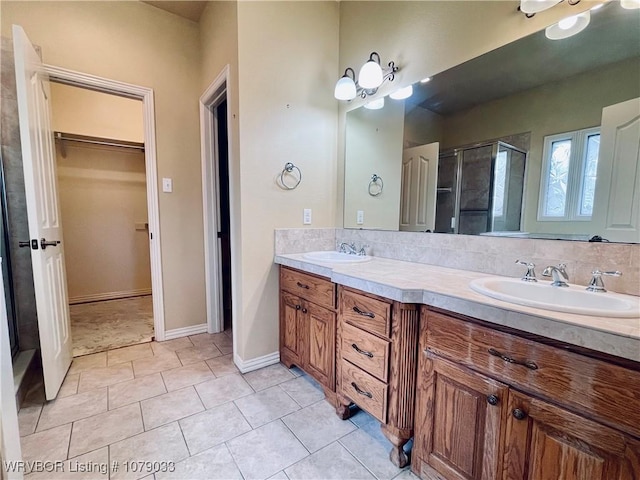 bathroom featuring a shower with door, vanity, backsplash, and tile patterned floors