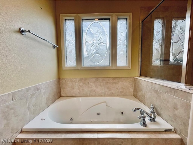 bathroom with a relaxing tiled tub