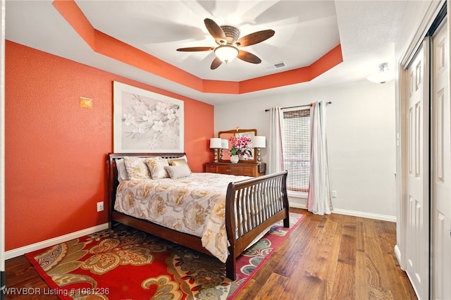 1524 Bunker Hill Ct, Van Buren, AR 72956 - bedroom with a tray ceiling, wood finished floors, baseboards, a closet, and a ceiling fan