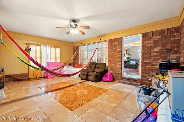 1524 Bunker Hill Ct, Van Buren, AR 72956 - living room with a wood stove, a ceiling fan, brick wall, and tile patterned flooring