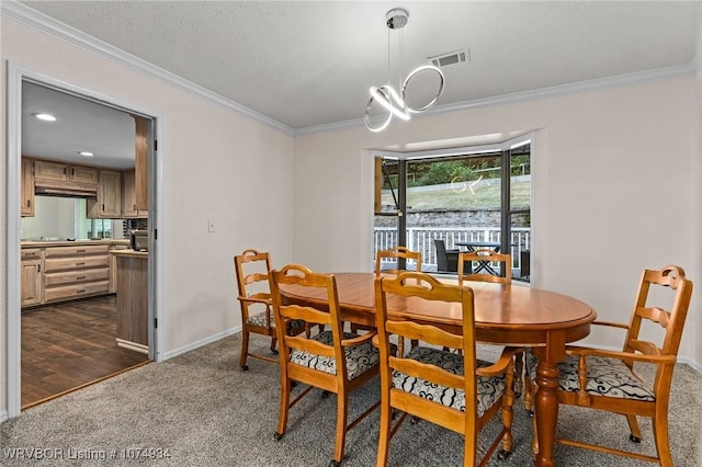 dining area featuring dark colored carpet, ornamental molding, and an inviting chandelier