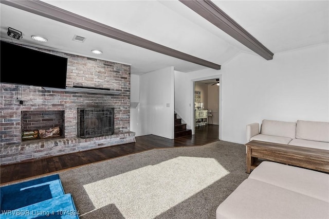 living room with ceiling fan, lofted ceiling with beams, a fireplace, and dark wood-type flooring