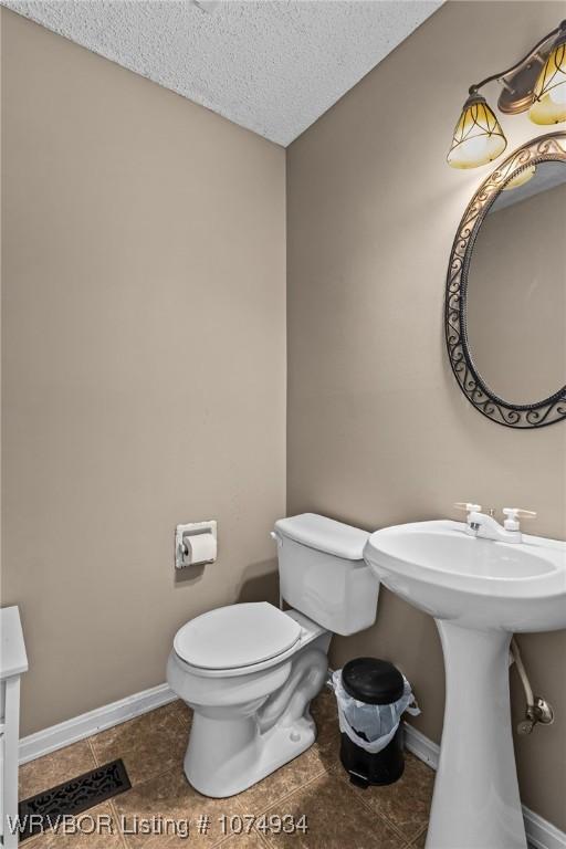 bathroom featuring toilet and a textured ceiling