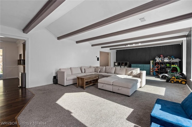 living room featuring beamed ceiling and dark carpet