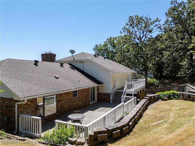 rear view of property with a wooden deck and a yard