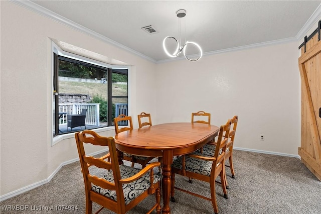 dining room featuring a barn door, crown molding, and carpet