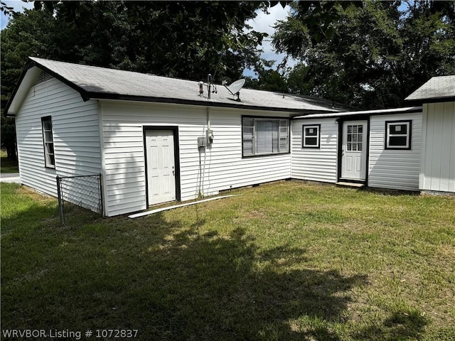 back of house with a lawn