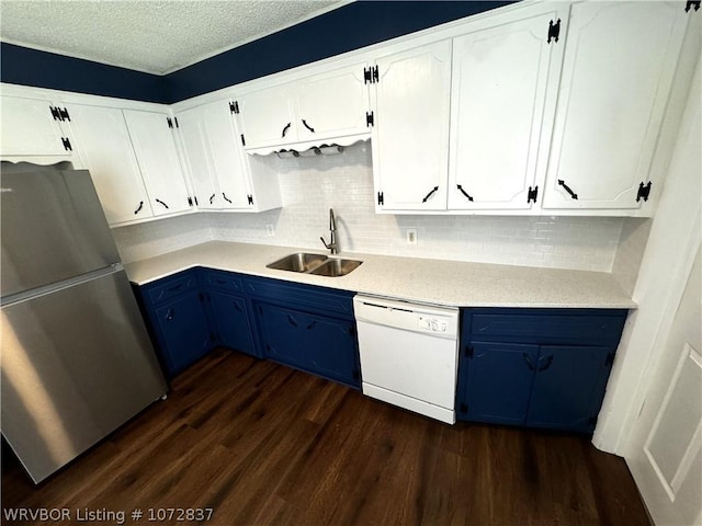 kitchen featuring white dishwasher, white cabinetry, sink, and stainless steel refrigerator