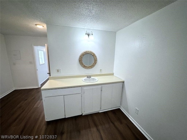 bathroom featuring hardwood / wood-style floors, vanity, and a textured ceiling