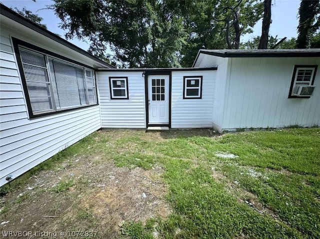 view of exterior entry with a yard