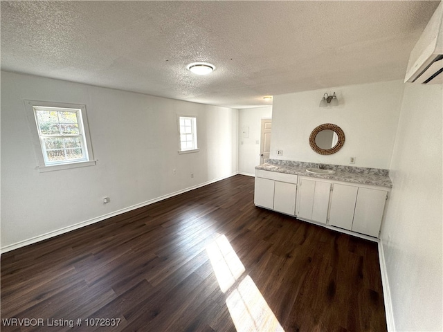 interior space featuring vanity, a textured ceiling, and hardwood / wood-style flooring