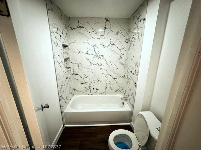 bathroom featuring wood-type flooring, toilet, and shower / washtub combination