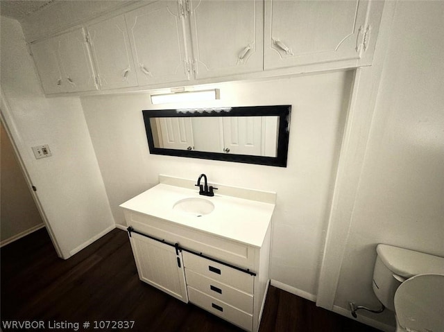 bathroom with vanity, hardwood / wood-style flooring, and toilet