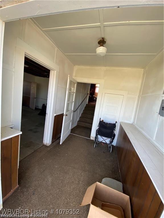 hallway featuring stairs and a decorative wall