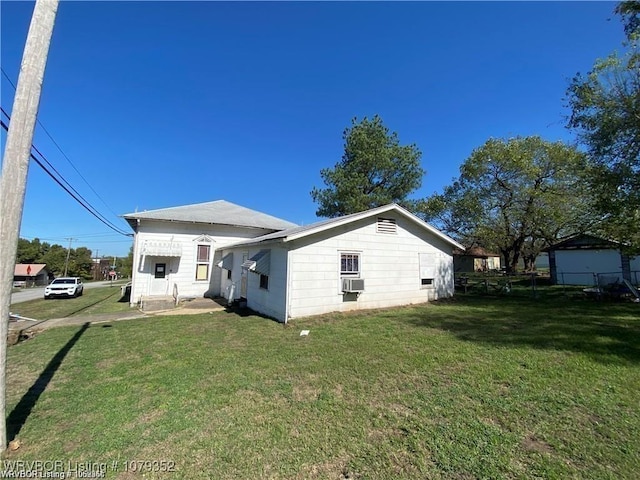 rear view of property featuring cooling unit and a lawn