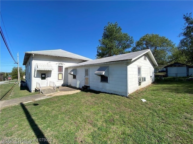 back of house featuring entry steps, a lawn, and cooling unit