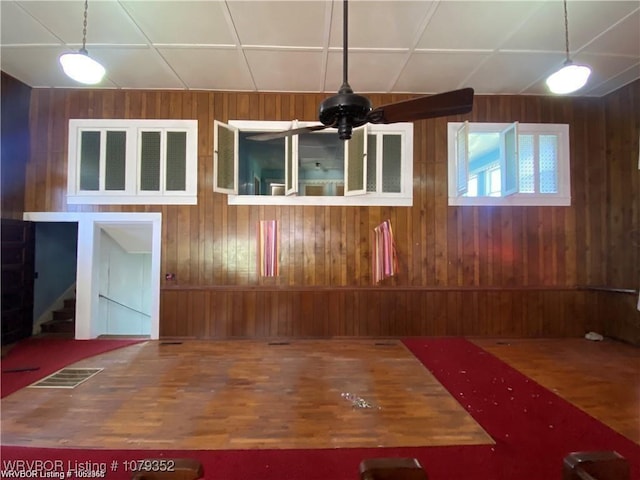 spare room featuring stairway, wood walls, and wood finished floors