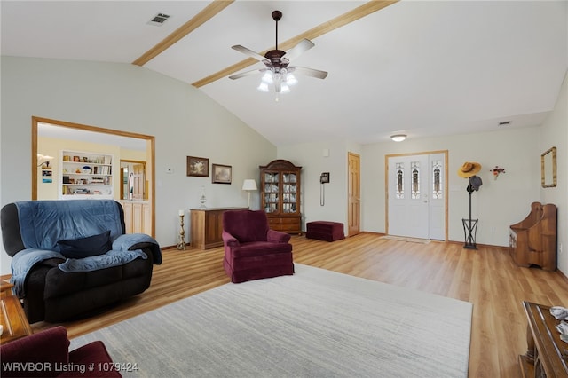 living room featuring lofted ceiling with beams, visible vents, and light wood-style flooring