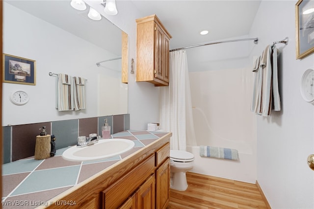 bathroom with toilet, shower / bath combination with curtain, wood finished floors, and vanity