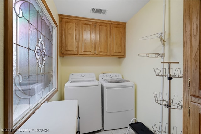 laundry area featuring visible vents, cabinet space, and washer and dryer