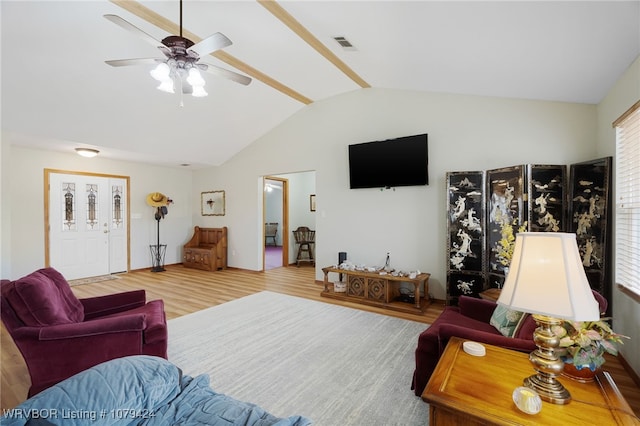 living area with lofted ceiling, visible vents, and wood finished floors