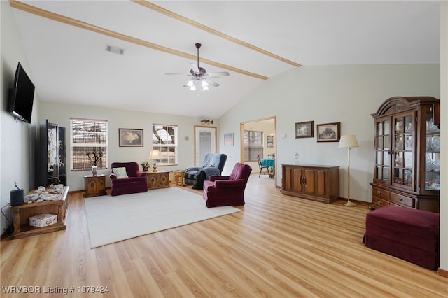 living area with a ceiling fan, visible vents, high vaulted ceiling, and wood finished floors