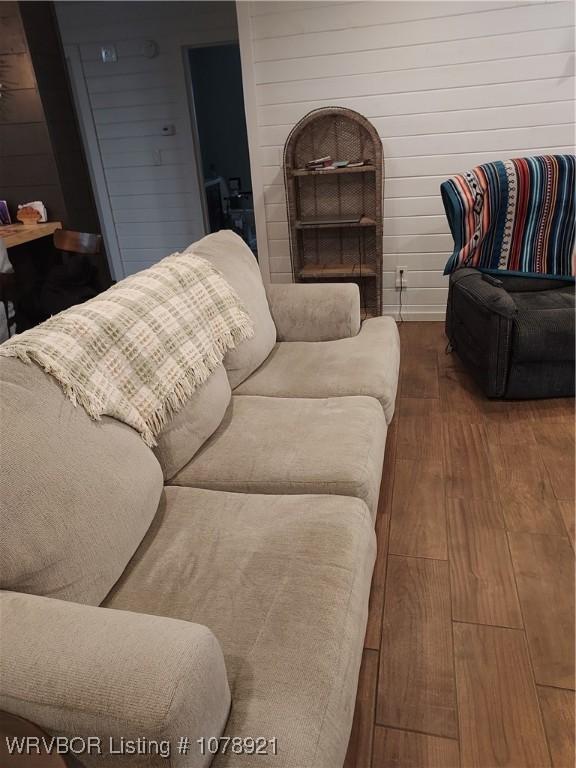 living room with hardwood / wood-style floors and wooden walls