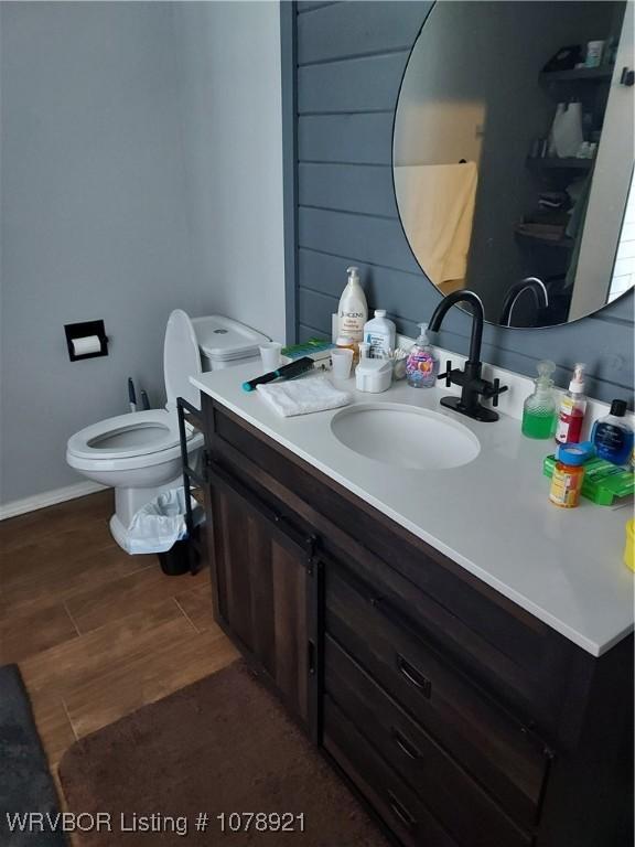 bathroom with hardwood / wood-style flooring, vanity, and toilet