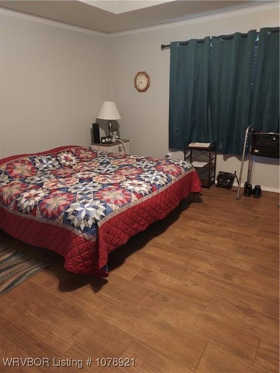 bedroom featuring crown molding and wood-type flooring