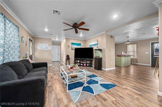 300 W Dutch Ave, Sallisaw, OK 74955 - living area with a ceiling fan, wood finished floors, a textured ceiling, ornamental molding, and recessed lighting