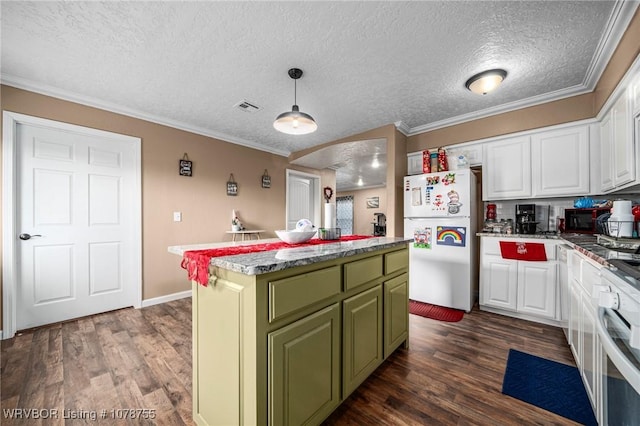 kitchen with white refrigerator, decorative light fixtures, a center island, and white cabinets