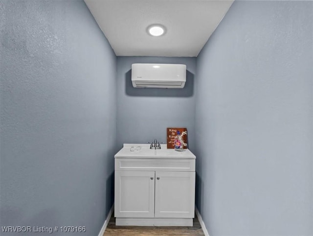 23805 270th Hwy, Howe, OK 74940 - bathroom with an AC wall unit, wood finished floors, baseboards, and vanity