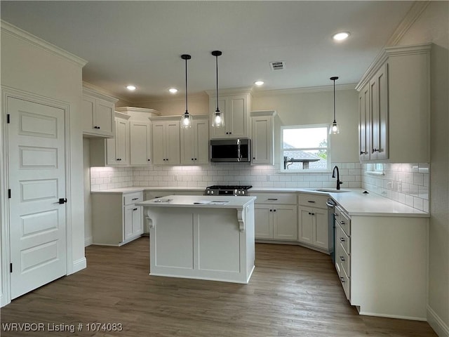 9114 Maysview Ln, Fort Smith, AR 72916 - kitchen featuring stainless steel microwave, stove, a sink, wood finished floors, and crown molding
