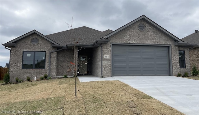 view of front of property featuring a front yard and a garage