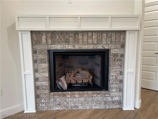 9114 Maysview Ln, Fort Smith, AR 72916 - detailed view of wood finished floors, baseboards, and a brick fireplace