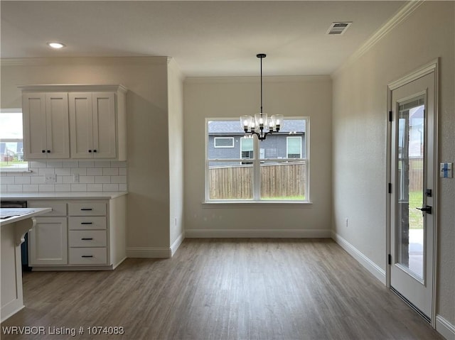 9114 Maysview Ln, Fort Smith, AR 72916 - kitchen with light wood-style floors, crown molding, a chandelier, white cabinetry, and light countertops