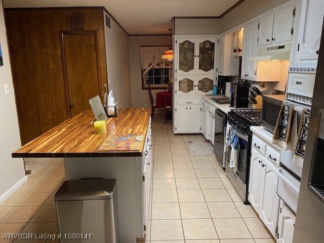 935 Florence Cir, Mulberry, AR 72947 - kitchen with wooden counters, black appliances, light tile patterned floors, under cabinet range hood, and white cabinets