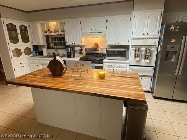 935 Florence Cir, Mulberry, AR 72947 - kitchen with appliances with stainless steel finishes, wooden counters, under cabinet range hood, white cabinetry, and light tile patterned floors