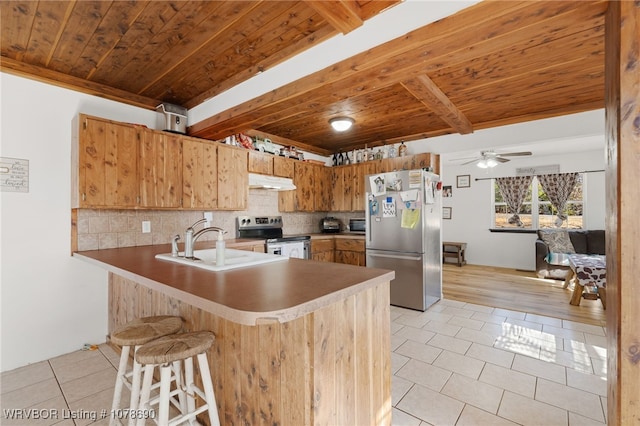 kitchen with backsplash, stainless steel appliances, kitchen peninsula, and light tile patterned floors