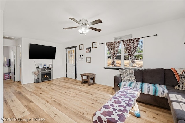 living room featuring light hardwood / wood-style flooring and ceiling fan