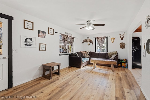 living room with ceiling fan and light hardwood / wood-style floors