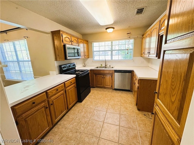 9506 Londonderry Ct, Fort Smith, AR 72908 - kitchen featuring appliances with stainless steel finishes, a textured ceiling, brown cabinets, light tile patterned floors, and light countertops