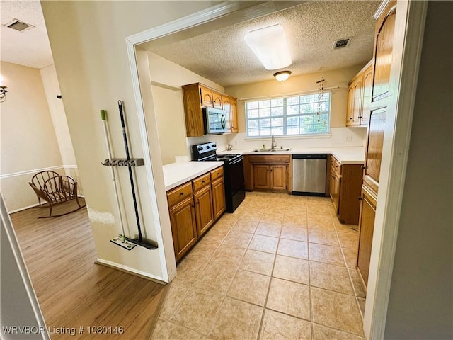 9506 Londonderry Ct, Fort Smith, AR 72908 - kitchen with stainless steel appliances, brown cabinetry, a textured ceiling, and light countertops