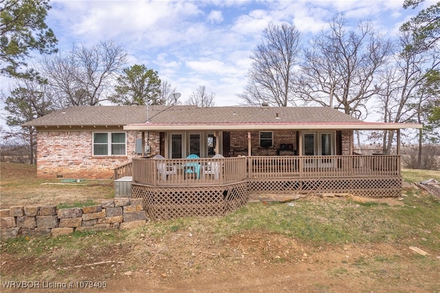 back of house featuring brick siding, crawl space, and a wooden deck