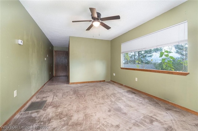 carpeted spare room with ceiling fan