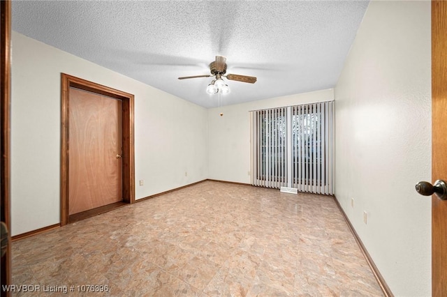 empty room featuring ceiling fan and a textured ceiling