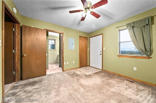 unfurnished bedroom with ceiling fan, light colored carpet, connected bathroom, and multiple windows