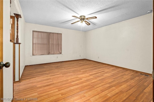 spare room with ceiling fan, light wood-type flooring, and a textured ceiling