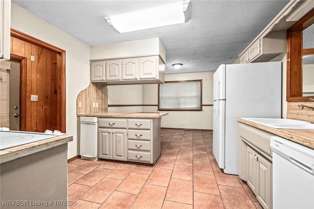 kitchen with white appliances, sink, decorative backsplash, a textured ceiling, and light tile patterned flooring